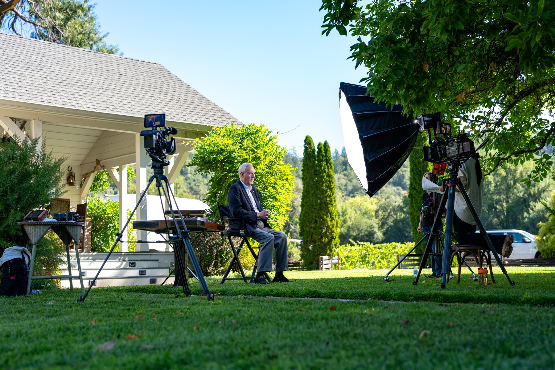 Two-camera outdoor interview beside a porch with a large soft key light